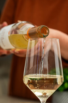 Close up of pouring white wine into glass at home