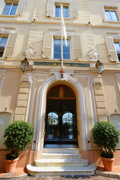 Entrance of the Town Hall of Monaco, with ornate gilded lettering, crowned coat of arms .