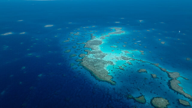 Boats float on the calm Red Sea waters near coral reefs