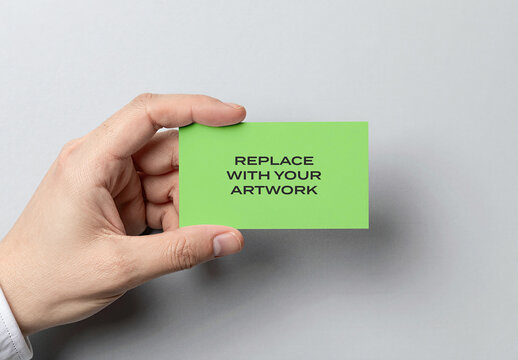 Business card mockup held in hand against a light gray background, realistic stationery presentation with placeholder text for artwork, clean design, minimalist branding, corporate identity