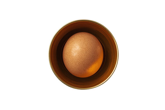 Whole brown egg in amber bowl viewed from above