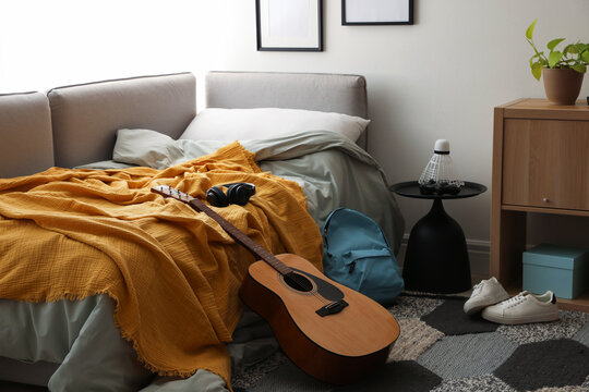 Teenager's room with stylish furniture and guitar. Interior design