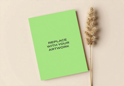 Vertical poster mockup displayed on a light beige surface with dried grass stem, realistic print presentation for branding, graphic design, advertising or editorial content