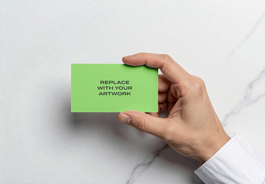 Business card mockup held in hand over a marble surface, realistic stationery branding presentation with placeholder text, template for print and digital display