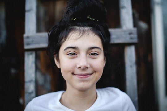 Close up portrait of a smiling teenage girl looking at the camera in soft natural light