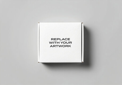 Cardboard box mockup on a neutral gray surface, top view flat lay presentation for branding, product display, and graphic design template with replace your artwork text