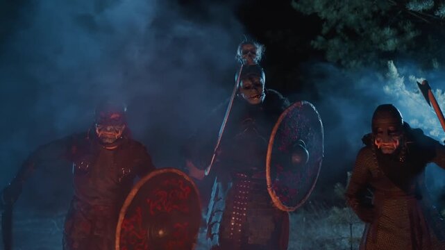 Three helmeted warriors in polished armor march forward through dense magenta and cyan smoke at night, raising round shields and gripping spears together in synchronized motion with dramatic glow