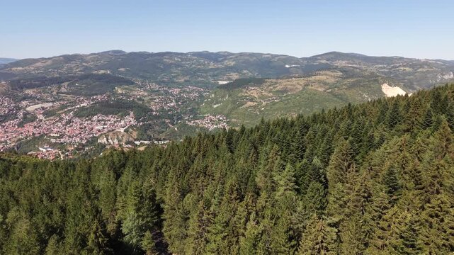Aerial Flyover of Evergreen Pine Forest on Trebevic Mountain Revealing Sarajevo City and Quarry, Bosnia and Herzegovina