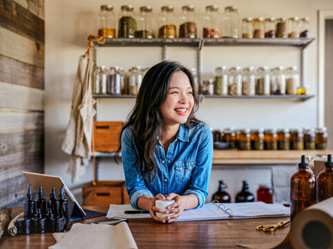 Smiling Woman Working in Herbal Apothecary Shop