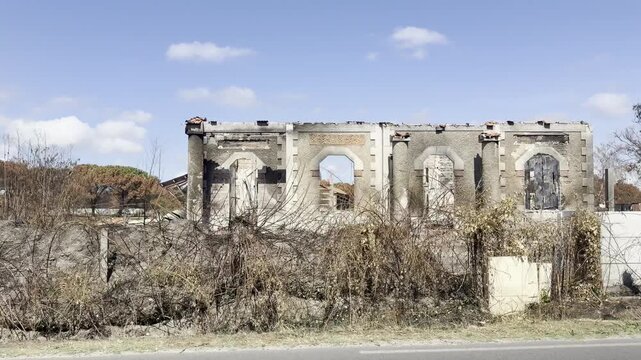 Le Porge, Gironde, France - July 2026: View from the D3 of three houses devastated by wildfire, with burned walls, damaged roofs and scorched vegetation.