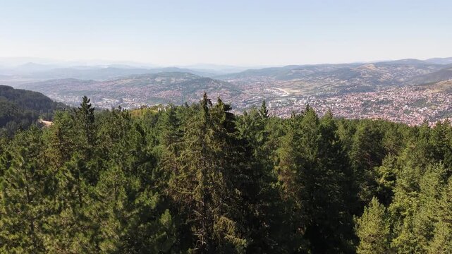 Drone Ascending Above Evergreen Pine Trees on Trebevic Revealing Sarajevo Valley Panorama, Bosnia and Herzegovina