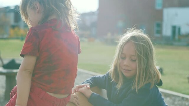 Close-up of two boys at a playground bathed in golden backlight