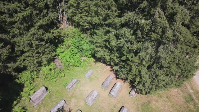 Aerial Flyover of Medieval Stecci Tombstones Necropolis Surrounded by Dense Forest in Bijambare, Bosnia and Herzegovina