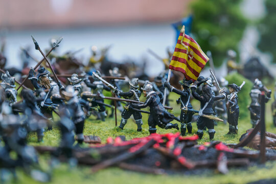 A miniature soldier figure with a flag on a battlefield.