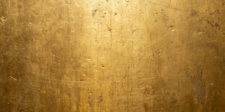 Textured metallic gold surface with subtle scratches and warm diffused lighting for backgrounds