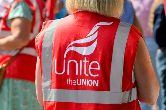 Pontypridd, Wales, UK - 31 July 2026: Member of the Unite Union wearing a reflective safety jacket at an outdoor event.