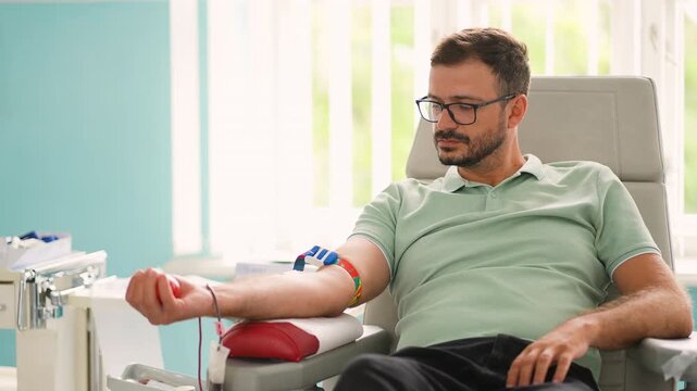 Male volunteer donating blood in hospital transfusion center
