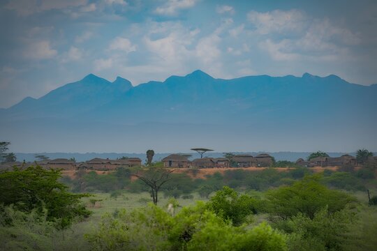 Scenic landscape view of african village settlement under blue mountain range