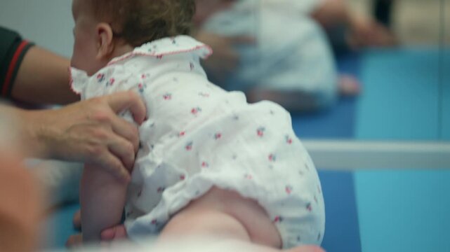 Baby girl receiving support from a physical therapist, engaging in early development exercises and tummy time
