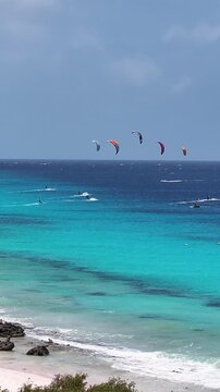 Kiteboarding Bonaire In Kralendijk Bonaire Netherlands Antilles. Tourists Parasailing Over A Tropical Ocean On A Sunny Day. Tropical Skyline. Beach Landscape. Kralendijk Bonaire.