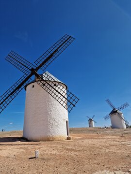 Historic whitewashed windmill towering against clear blue sky in Campo de Criptana, La Mancha