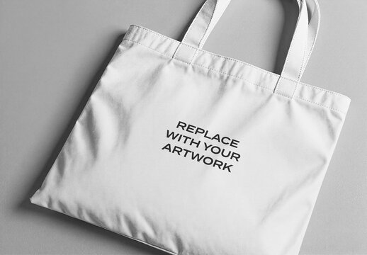 Canvas tote bag mockup with replace your artwork text displayed on a flat surface, minimalist product presentation for branding, graphic design, Template, and print applications