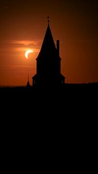 Vertical Drone Video of Partial Solar Eclipse Behind Bouzov Castle at Sunset in Czech Republic.