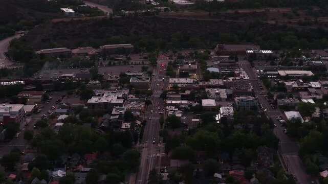 Aerial of downtown Durango Colorado residential and commercial areas at dusk along main street with traffic lights in summer