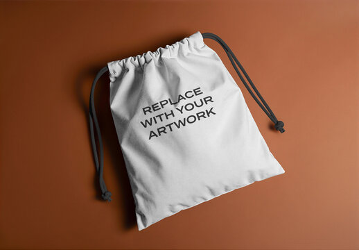 Drawstring bag mockup with black drawstrings on a brown surface, flat lay studio shot soft lighting and clean composition, realistic product presentation for branding graphic design