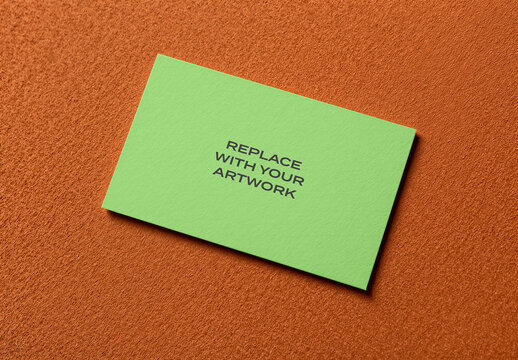 Business card mockup on a textured orange surface in flat lay composition, realistic stationery presentation with placeholder text for branding design and print display, top view