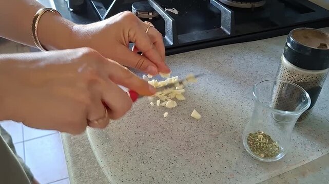 Chopping garlic and preparing spices in a kitchen