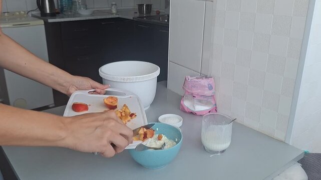 Cooking simple fruit salad in the kitchen with chopped peach and yogurt