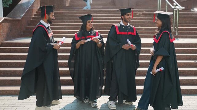 Happy indian students celebrating graduation day outside university