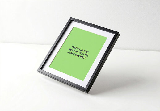 Framed poster mockup with placeholder text displayed on a white surface against wall, realistic interior presentation for graphic design and print display, template