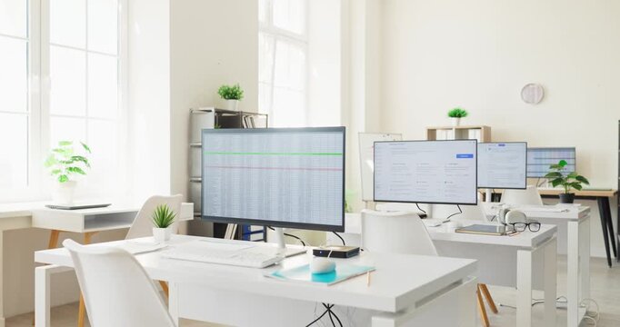 Office computers monitors in workspace show spreadsheet. Modern desks display data finance dashboards for technology analysis. Minimal clutter for productivity. Focus on data analysis concept.
