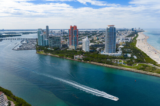 Yacht cruising near Miami skyline. Aerial view of boats on turquoise waters in Miami.