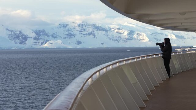 Antarctica Cruise Ship Male Photographer On Deck Alone at Sunset. Professional Camera, Albatross Flies By, Adventure Travel, White Man Black Coat