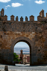 Obraz premium Medieval City Gate Arch Framed View of Landscape and Tower in Avila Spain