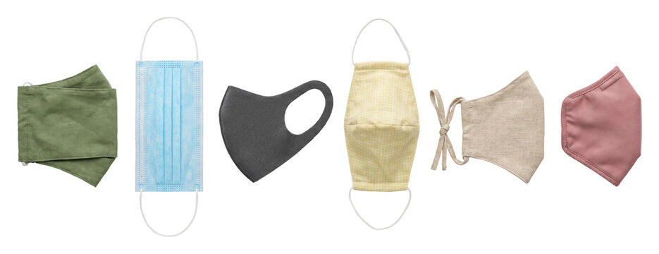 Collection of various protective face masks including disposable surgical, reusable fabric, and foam types are arranged in a horizontal row showing different colors and materials