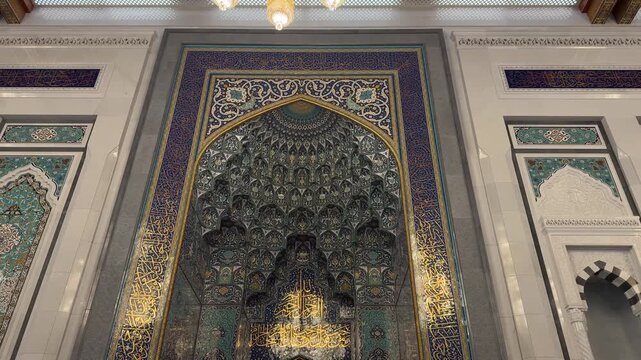 Ornate mihrab with Islamic calligraphy and intricate decoration inside Sultan Qaboos Grand Mosque