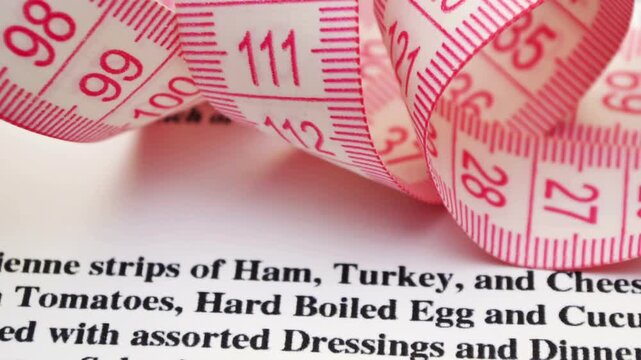 Measuring Tape on Recipe Document Representing Portion Size and Nutrition Measurement