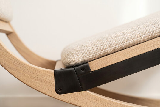 The elegant joint where a matte-steel frame connects with a light-oak curved runner