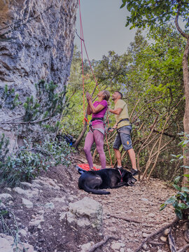 Couple preparing rock climbing adventure with dog