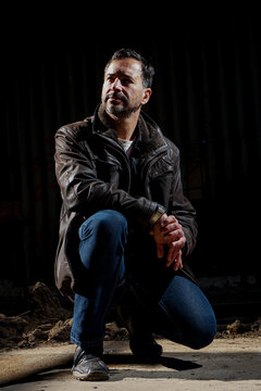A stylish, dark-haired, slim, 40-year-old white man. He is wearing blue jeans and a brown fur coat.