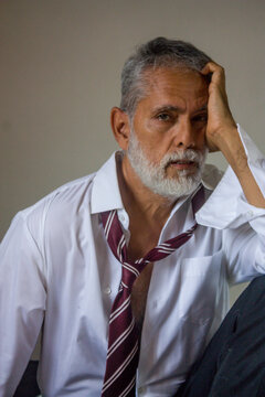 Tired Businessman Holding Head in Hand Studio Portrait
