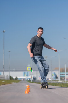 A Caucasian man rollerblades around the slalom course.