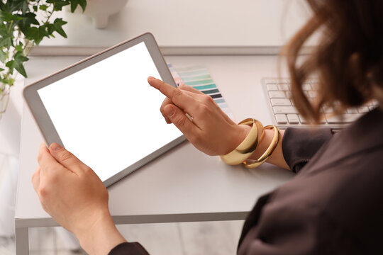 Digital design and creative work, woman using a tablet with blank screen for mockups and presentations at a modern desk