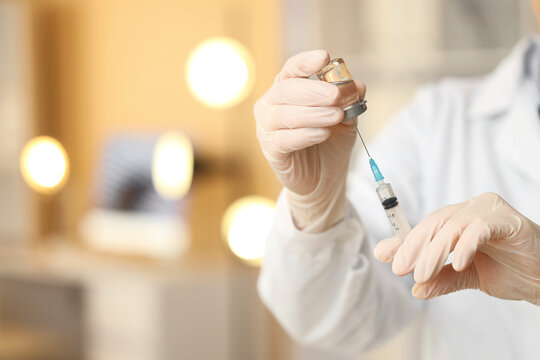 Vaccine development and medical research, doctor or scientist preparing injection with syringe and vial in laboratory