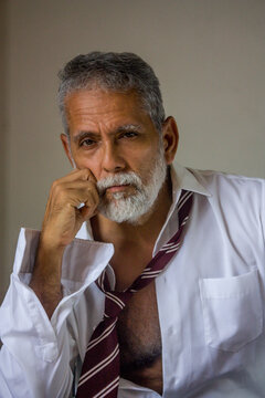 Thoughtful Senior Man Resting Head on Hand Studio Portrait