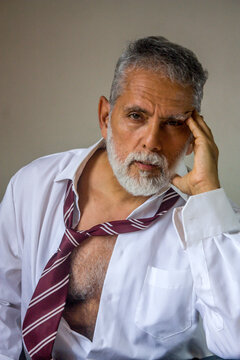 Intense Senior Man Holding Head in Hand Studio Portrait